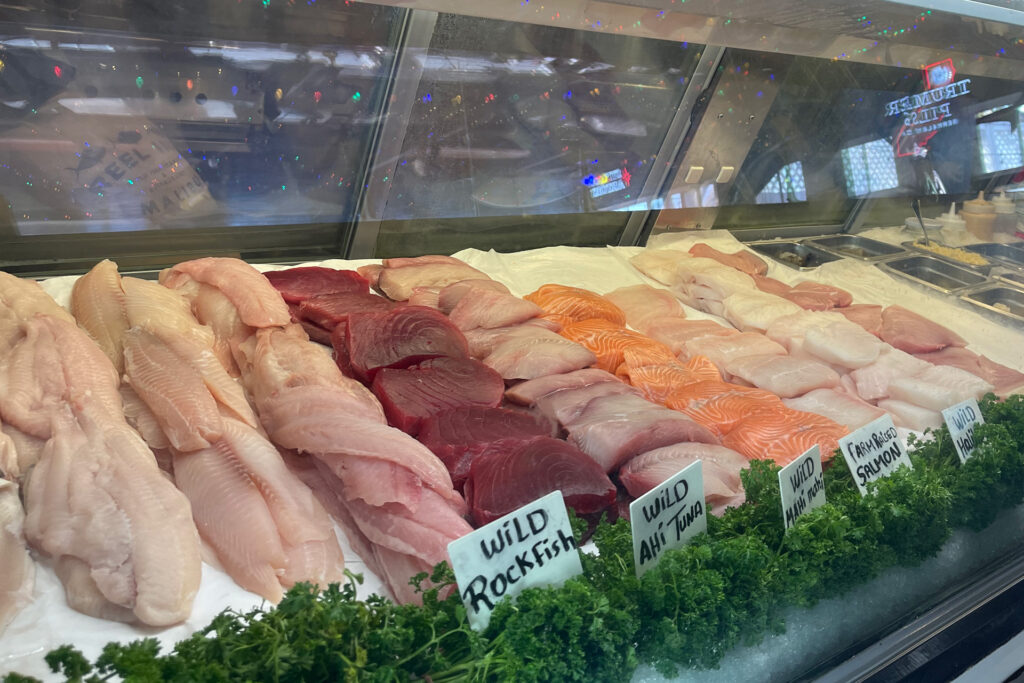 Photo of a glass case with rows of fresh caught fish available to order.